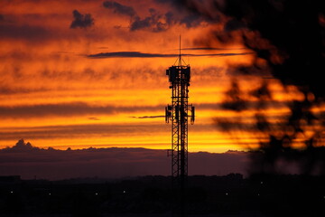 Naklejka premium Telecommunication tower at sunset with dramatic sky