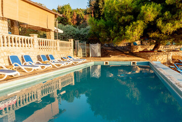 Outside outdoor pool with blue water in backyard of country house cottage