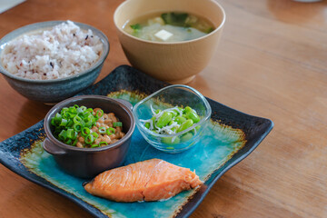 Traditional Japanese breakfast with grilled salmon, natto, miso soup and rice
