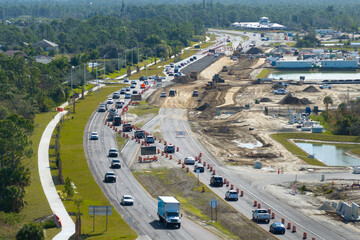 Highway construction in North Port, Florida. Development of American road with moving traffic cars. City transportation improvement