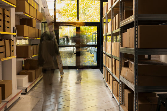Busy employees in motion at small facility highlight nonstop pace of shipment service, packaging and logistics in a depot stock room handling retail and online shopping orders.
