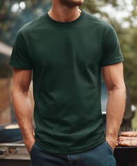 A product mockup photo of a blank dark military green Gildan 64000 tshirt being worn at an outdoor bbq by a gym bro in his late 20s Focus on the tshirt no des