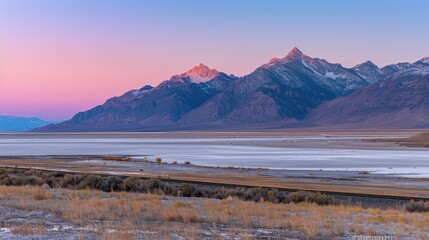 Scenic Mountain Range with Pink and Blue Sunset Sky Over Flat Valley Landscape