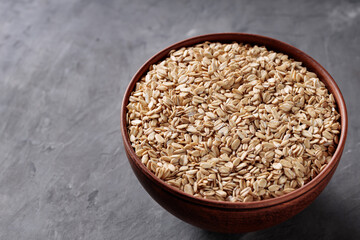 Rolled Oats in Ceramic Bowl on Gray Surface Copy Space