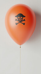 An orange balloon with a simple black flat icon of a silhouette of Halloween skull and cross bones printed on it