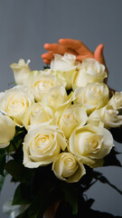 The florist holds a bouquet of beautiful white roses. The bouquet was made to order.