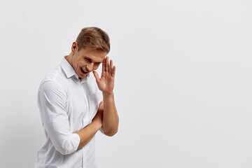 Smiling man in white shirt looking cheerful and relaxed against a plain white background,...