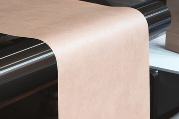 Machine with roll of brown kraft paper on it. Machine is in factory. industrial food packaging...