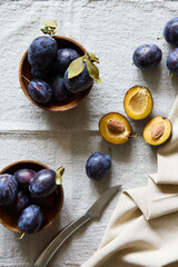 Ripe purple plums in a plate on a table top view indoors