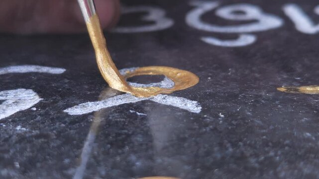 Close Up Of An Indian Sculptor Artist Panting On Engraved Stone