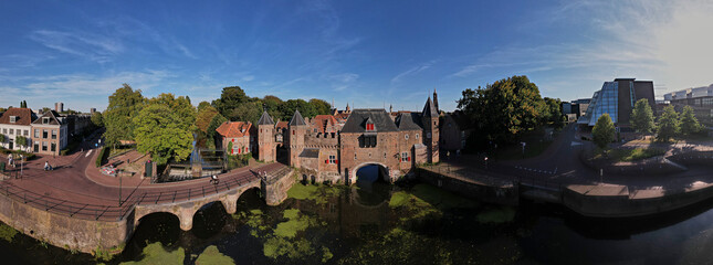 180 degree panorama with reflection of the double gated medieval city entrance Koppelpoort structure in Amersfoort, The Netherlands, reflecting in the Rijn canal water in the foreground on a sunny day