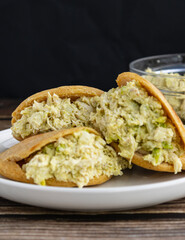Venezuelan arepa Reina Pepiada stuffed with shredded chicken and creamy avocado. Authentic Latin street food with traditional homemade flavor