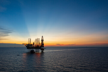 Aerial view of offshore jack up rig in a shipyard during sunset for oil and gas exploration and production. 