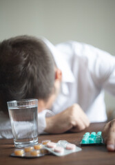 Man in a White Shirt Contemplating with an Hourglass and Medication stress