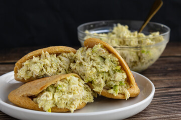 Venezuelan arepa Reina Pepiada stuffed with shredded chicken and creamy avocado. Authentic Latin street food with traditional homemade flavor