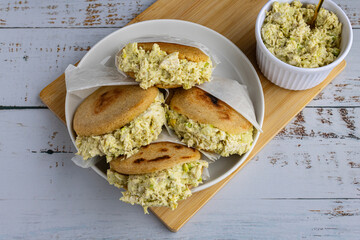 Venezuelan arepa Reina Pepiada stuffed with shredded chicken and creamy avocado. Authentic Latin street food with traditional homemade flavor