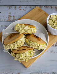 Venezuelan arepa Reina Pepiada stuffed with shredded chicken and creamy avocado. Authentic Latin street food with traditional homemade flavor