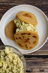 Venezuelan arepa Reina Pepiada stuffed with shredded chicken and creamy avocado. Authentic Latin street food with traditional homemade flavor