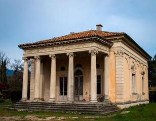 Obraz premium Old, light beige temple-like building in a garden