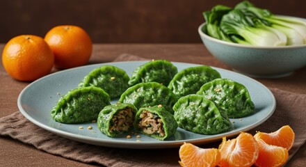 Vibrant green dumplings filled with delicious stuffing served alongside fresh tangerines and bok choy create an appetizing culinary experience