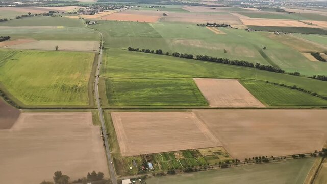 A breathtaking aerial view displays the diverse farmland characterized by rich greenery and beautiful patterns