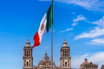 Mexican flag in Zocalo Constitution Square. Mexico city, Metropolitan Cathedral and National Palace.