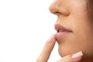 Obraz premium Young woman touching her dry lips, close up. Skin care and lip care concept. Selective focus.