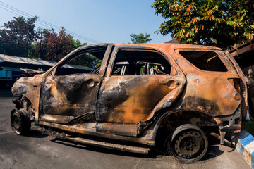 The car after it caught fire. Some parts of the car appear charred.