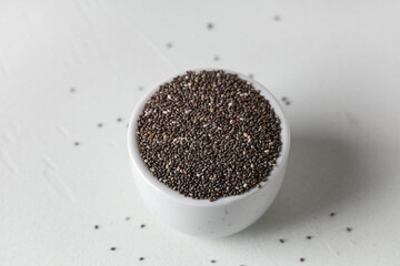 Bowl with chia seeds on white background