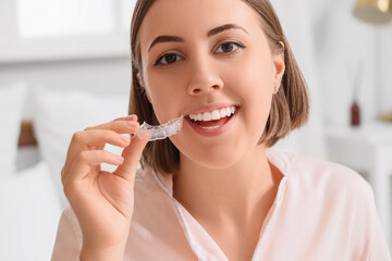 Young woman with occlusal splint in bedroom, closeup