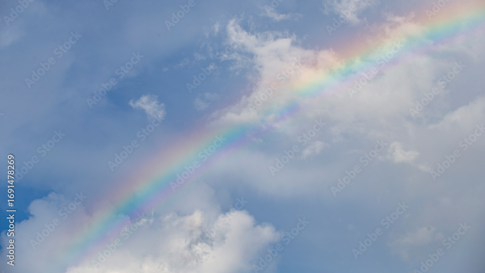 Canvas Prints rainbow in the blue sky with white clouds and copy space.