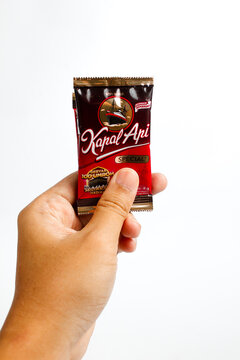 Indonesia, Sukoharjo - June 19, 2025 : holding a sachet of ground coffee product steamer (Kapal Api )brand from Indonesia, Isolated on white background