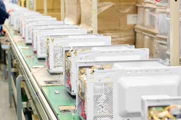 Assembly workshop showcasing the production line for household microwave ovens at a manufacturing...