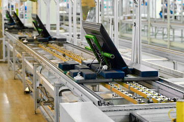 Production line at a television manufacturing plant showcasing units on a conveyor belt in an assembly area