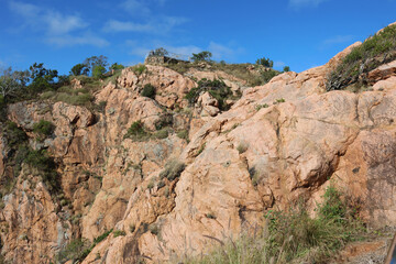 Rocky hillside with big reddish-brown stones and a fenced lookout spot at Castle Hill in Townsville, Queensland, Australia