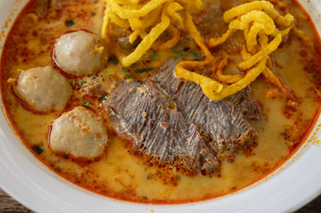 Close up of a beef Khao soi (Northern Thai Coconut Curry Noodle Soup). Khao soi is one of the most popular Thai dishes to eat in northern Thailand, especially in Chiang Mai and Chiang Rai.