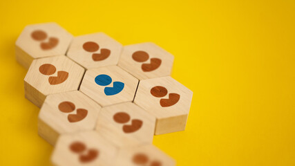 Unique Blue Person Among Brown Wooden Hexagon Blocks on Yellow Background