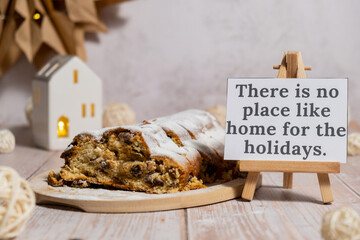 Paper note with text THERE IS NO PLACE LIKE HOME FOR THE HOLIDAYS. Homemade Christmas traditional...