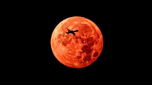 Dramatic silhouette airplane crossing a vibrant blood moon in the night sky, ideal for travel posters, cosmic art, or science fiction themes - Powered by Adobe