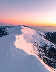 cinematic drone shot of a serene, snowy mountain range at sunset, 