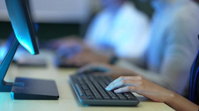 A software developer's hands type rapidly on a keyboard, writing source code in an IDE. This illustrates the fast-paced nature of data input in a tech environment.