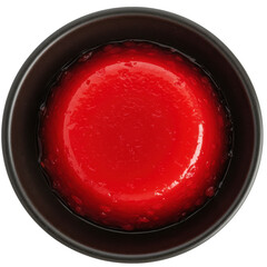 Glossy red flan dessert in dark brown ceramic bowl top down view isolated on white background