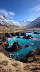 Iceland's majestic coastal scene turquoise waters meet snow-dusted peaks under a bright blue sky. Dramatic cliffs and golden grasses add to the allure