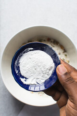Overhead of baking soda or baking powder in a blue plate
