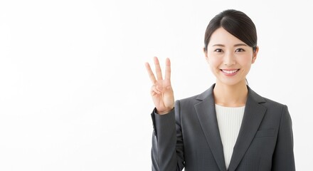 3番目のジェスチャーをしている笑顔の日本人女性社員