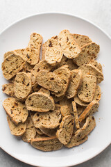 Overhead view of toasted bread chips on white background, top view of crostini bread on marble countertop
