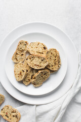 Overhead view of toasted bread chips on white background, top view of crostini bread on marble countertop