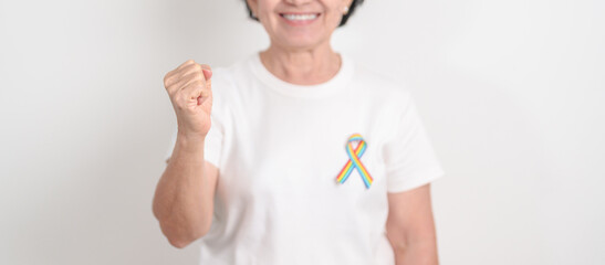 Elderly with LGBTQ Rainbow ribbon for concept of June Pride month, April Autism Awareness, All cancer Awareness, February World Cancer day, October World Hospice and Palliative care day and Survivor