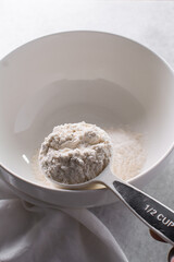 overhead view of All purpose flour in a white mixing bowl, top view of baking flour in a ceramic bowl
