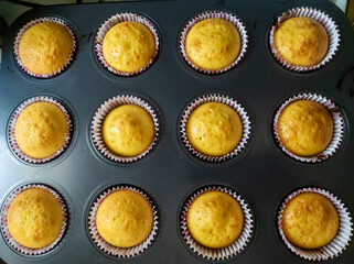 A muffin tray filled with muffins sitting on top of a stove
